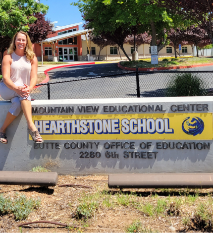 Principal Haight sitting on the Hearthstone School sign.