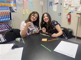 Two students showing off their robotic hand science project